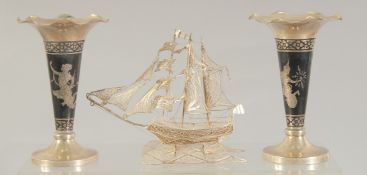 A PAIR OF THAI STERLING SILVER BUD VASES, together with a silver filigree sailing ship, (3).