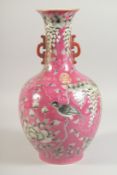 A CHINESE PINK GROUND TWIN HANDLE PORCELAIN VASE, decorated with bird and flora, four-character mark