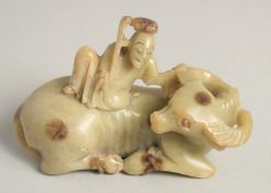 A SMALL CHINESE CARVED SOAPSTONE GROUP, depicting a figure on an oxen, 9cm long.