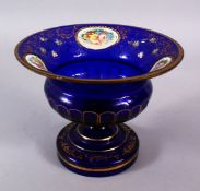 A 19TH CENTURY ENAMEL BLUE BOHEMIAN GLASS TAZZA, with enamel floral panel & gilt decoration, 16cm