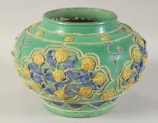 A CHINESE GREEN GROUND FAHUA POTTERY JAR, with relief floral motifs, 22cm diameter.