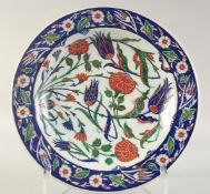 A TURKISH OTTOMAN GLAZED POTTERY PLATE, decorated with flora, 36cm diameter.