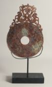 A CHINESE HARDSTONE DISK, raised on stand, the disk with relief decoration depicting various beasts,