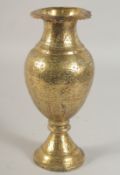 AN INDIAN ENGRAVED AND CHASED BRASS VASE, 24cm high.