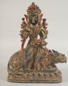 A GILT BRONZE DEITY SEATED UPON A MYTHICAL BEAST, 32cm high.