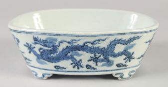 A CHINESE BLUE AND WHITE PORCELAIN PLANTER, with dragons and stylised clouds, raised on four feet,