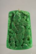 A CARVED JADE PENDANT with gold ring.