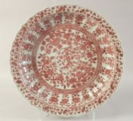 A CHINESE UNDERGLAZE RED PORCELAIN CHARGER, decorated with flora, 48cm diameter.