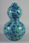 A CHINESE TURQUOISE GROUND BLUE AND WHITE DOUBLE GOURD VASE, decorated with gourds and bats, six-