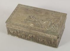 A CHINESE EMBOSSED METAL DRAGON BOX, the sides with floral relief decoration, 23cm x 13cm.