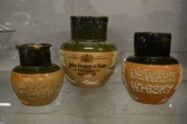 Three Royal Doulton Dewar's whisky jugs.