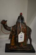 A painted spelter table lighter modelled as Arab carpet sellers on a camel.