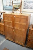 A 1930's oak small two door compactum in the manner of a Cotswold school.