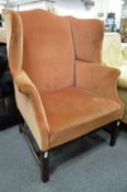 A George III mahogany framed wing armchair.