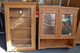 A small pine hanging cabinet with glazed door together with a pine bathroom cabinet.