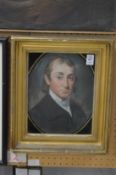 A 19th century English School, head and shoulders portrait of a young man in a Verre Eglomise and