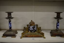 A brass and porcelain three piece desk set comprising: inkwell and pair of candlesticks.