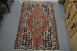A small Persian rug with geometric decoration 124cm x 76cm.