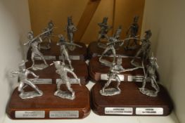 A set of six cast metal models of soldiers on wooden bases.