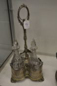 A plated triple decanter cruet containing a pair of cut glass decanters.