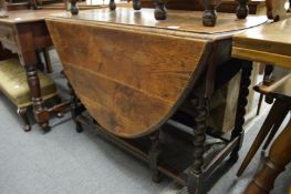An oak dropleaf gateleg dining table on barley twist legs.