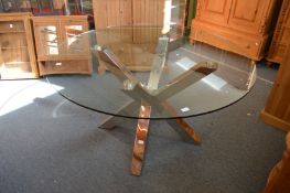 A stylish circular glass top coffee table on chrome support.