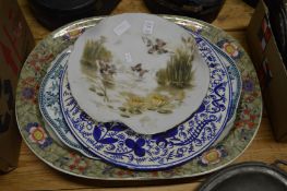 An opaque glass dish, Continental charger and two large meat dishes.