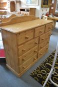 A large modern pine chest of drawers.