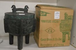 A small Chinese bronze effect ice bucket.