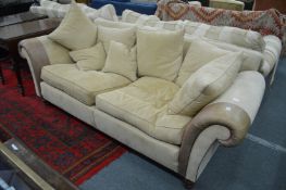 A large suede and leather upholstered two seater settee.