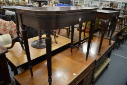 A George III mahogany D shaped foldover tea table on reeded tapering legs.
