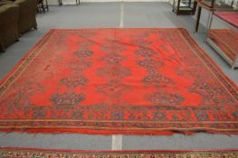 A Turkish carpet, bright red ground with stylised decoration, worn 356cm x 356cm.