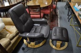 A brown leather upholstered Scandinavian massaging swivel reclining armchair with matching foot