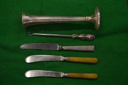 A silver bud vase and other items.