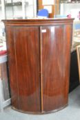 A George III mahogany bow front hanging corner cupboard.