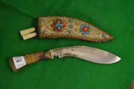 A miniature Kukri with decorative scabbard.