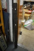A tall narrow carved wood panel.