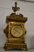 An ornate brass mantle clock.