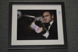 A small photographic print of Daniel Craig, bears initials.