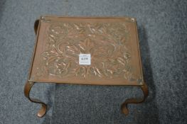An embossed copper trivet.