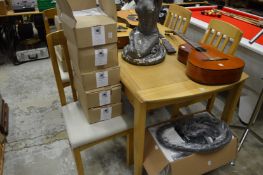 A modern oak extending dining table with one extra leaf and four chairs.