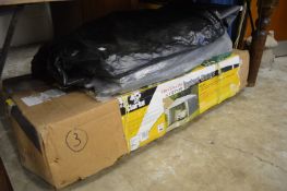 A Clarke instant garage, comprising tubular framework and grey tarpaulin covering.