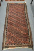 A Persian rug, dark blue and red ground with stylised decoration 198cm x 83cm.