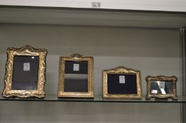 Four silver photograph frames.