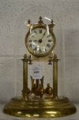 A brass anniversary style clock with glass dome.