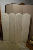 A classically upholstered four panel folding dressing screen.