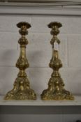 A pair of ornate cast brass candlesticks.