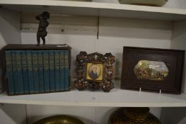 A miniature set of books, miniature portrait of a gentleman and a framed pot lid.
