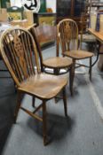 A pair of wheelback dining chairs and a bentwood chair.