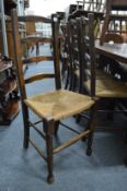A set of four oak ladderback dining chairs.